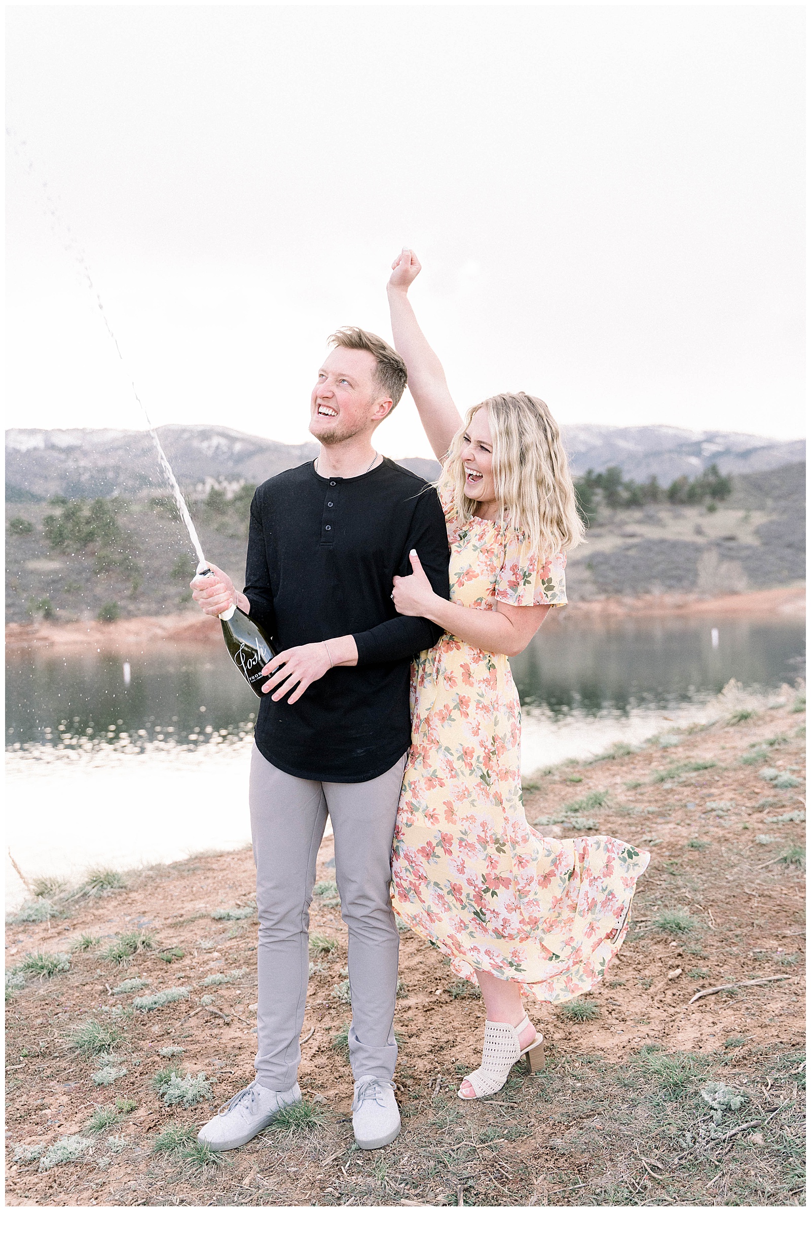 couple popping champagne at engagement session